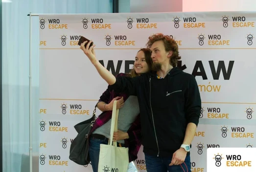 A couple taking a photo on the WroEscape 2017 wall
